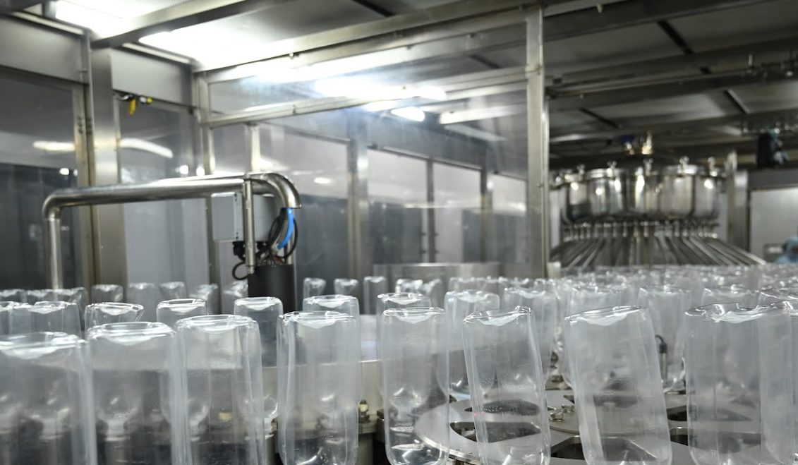 Empty bottles inverted in the rinser
