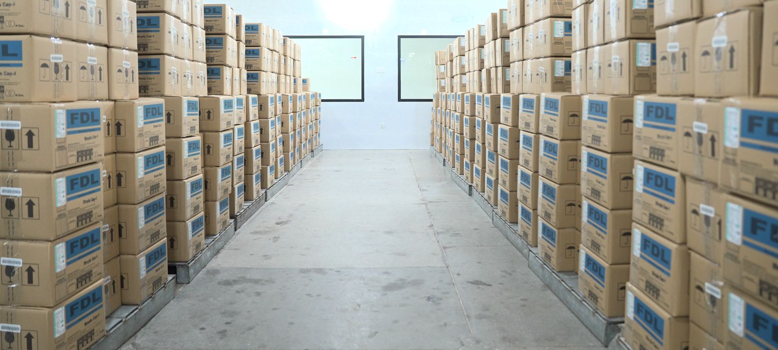 A warehouse aisle lined with stacked FDL cartons